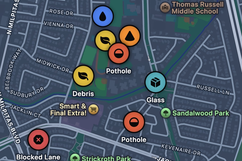 The live Blind Spot hazard map showing geo-tagged pins for potholes, debris, glass, and a blocked lane across a city neighborhood